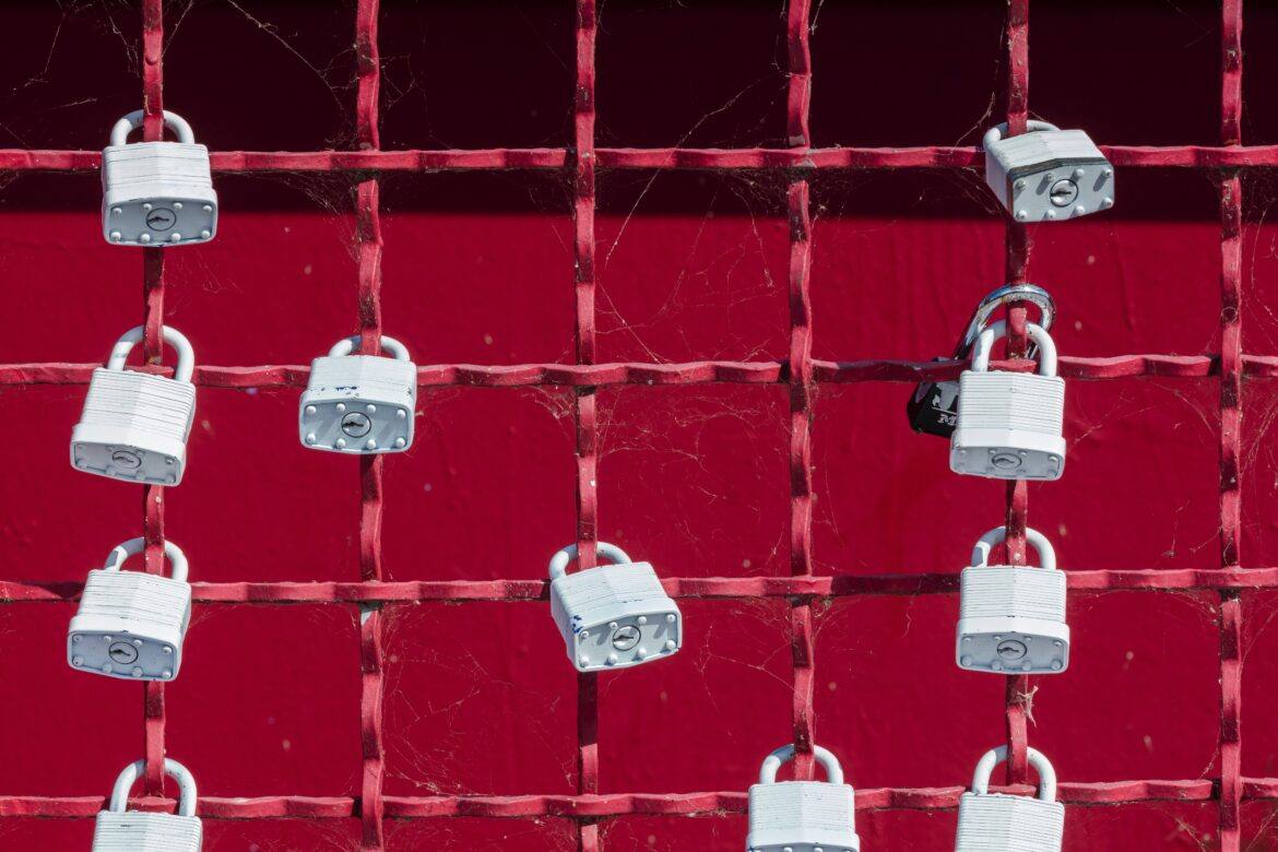 jon-moore-bBavss4ZQcA-unsplash Fence with padlocks affixed to individual strands