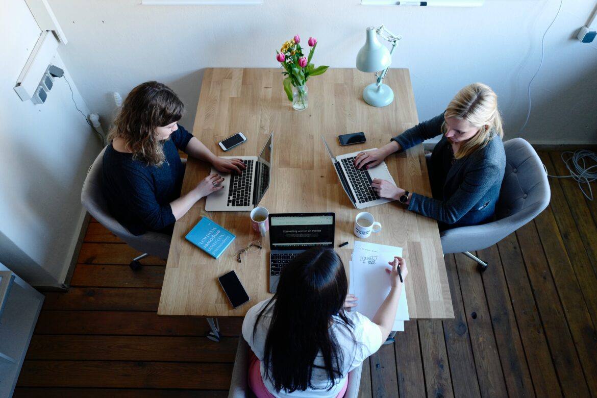 cowomen-7Zy2KV76Mts-unsplash 3 adults sitting at a table with devices
