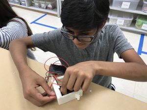 Student wiring flashlight while building global connections