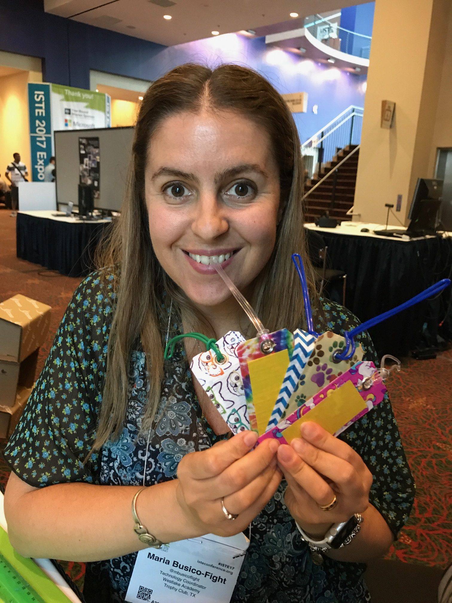 Maria holding up several duct tape luggage tags at  the convention.
