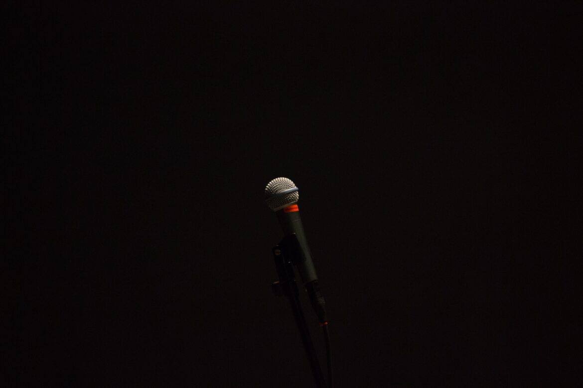 daniel-sandvik-18B9D4q9ESE-unsplash microphone against dark background