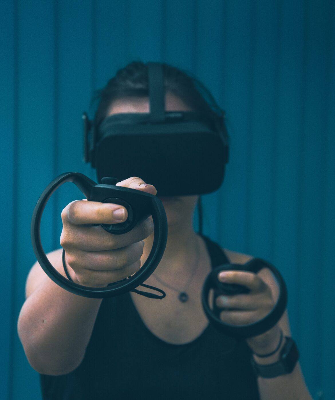 christine-sandu-VU3Gmeks-LY-unsplash woman with oculus rift virtual reality mask on face and controls in hands