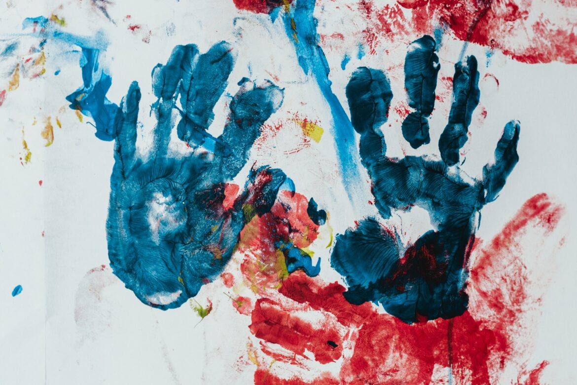 bernard-hermant-5zu86kyV_UY-unsplash handprints made of blue and red paint on a white canvas