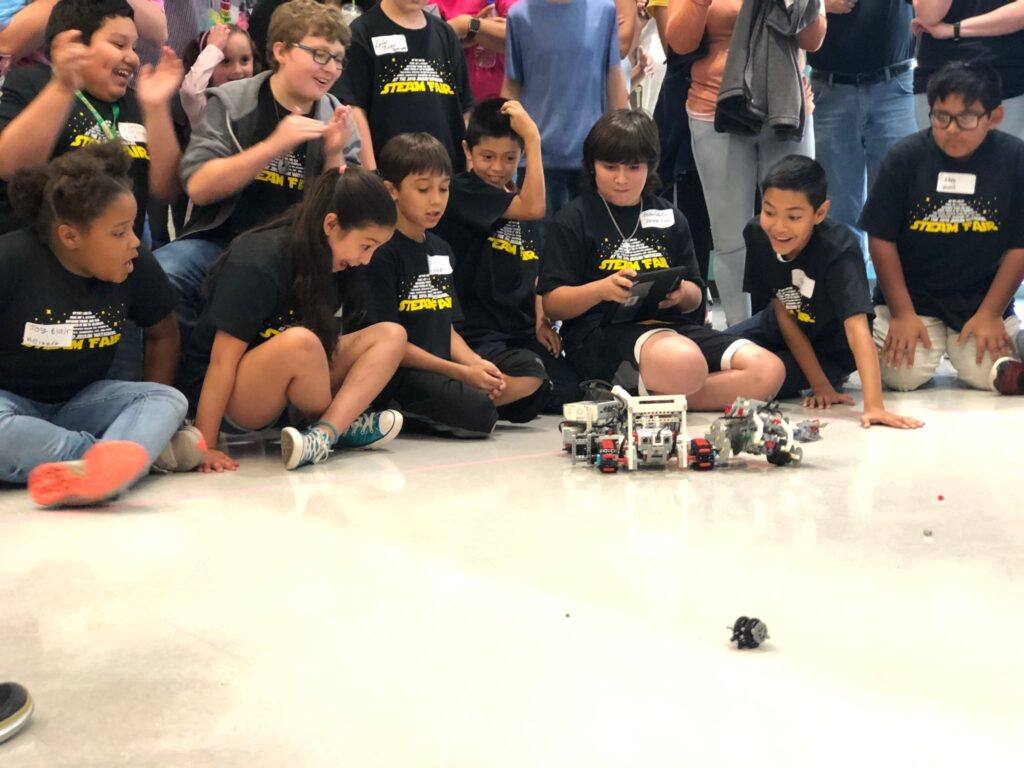 Several students with their two battle robots.