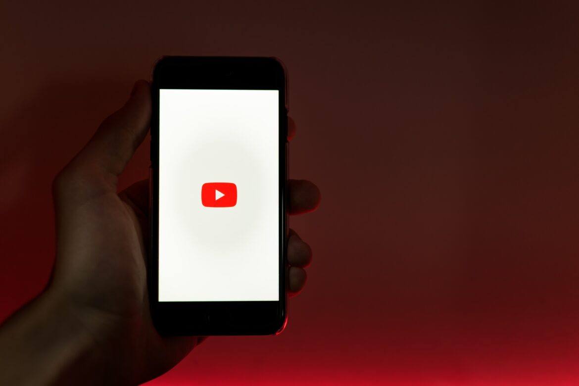 szabo-viktor-UfseYCHvIH0-unsplash hand holding smartphone with youtube logo on it