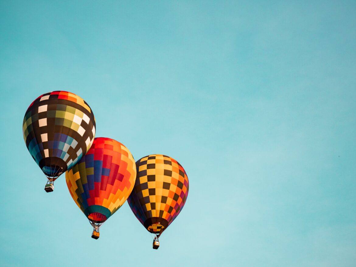 aaron-burden-GFpxQ2ZyNc0-unsplash three hot air balloons