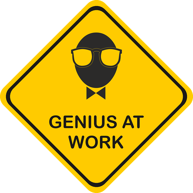 yellow sign with text "genius at work" with graphic of nerd
