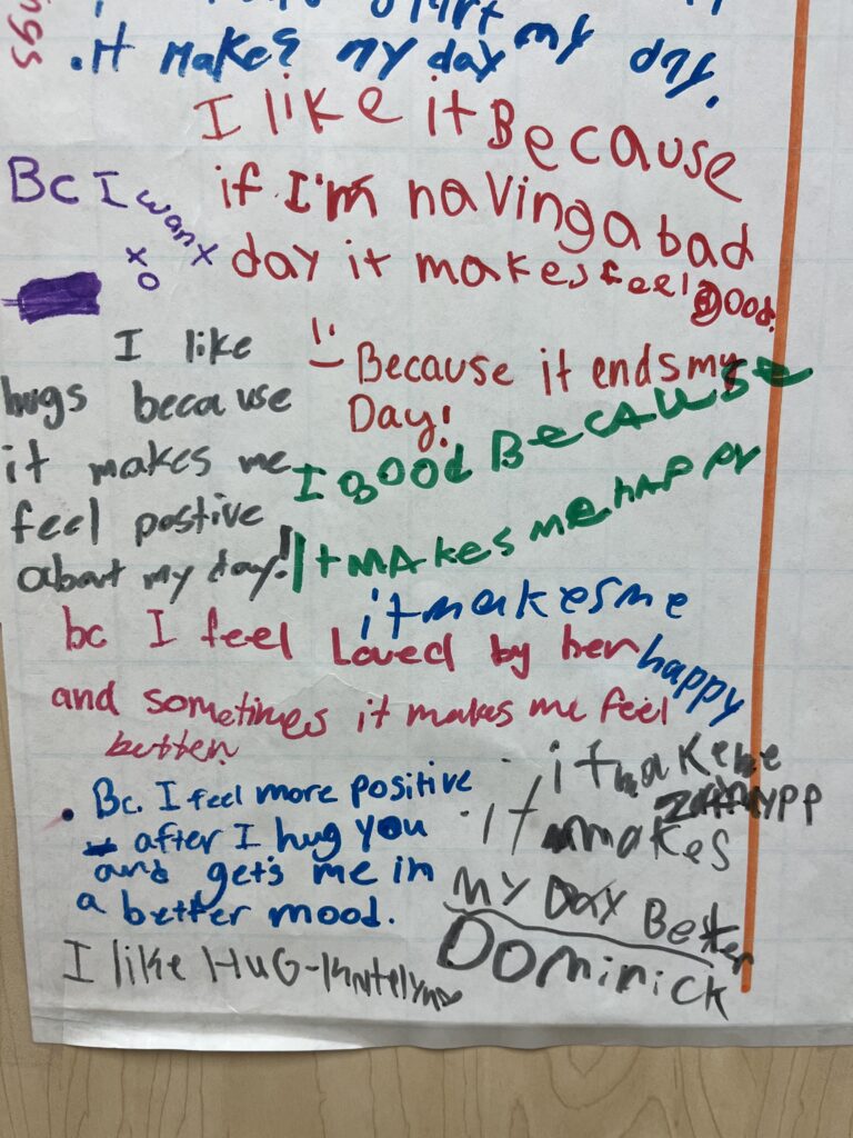 Image of a poster where students have written why they choose a hug for the morning greeting.