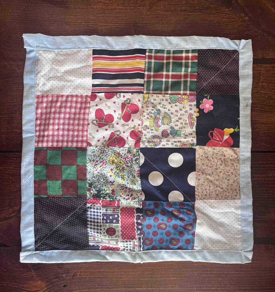 A 16x16 inch (4x4 quilt block) doll quilt sewn by the author and her grandmother.