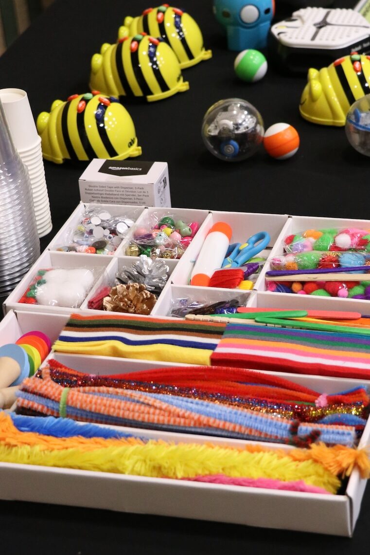 Colorful supplies sit on a black table in preparation for an ETC hands-on activity with Bee-Bots.