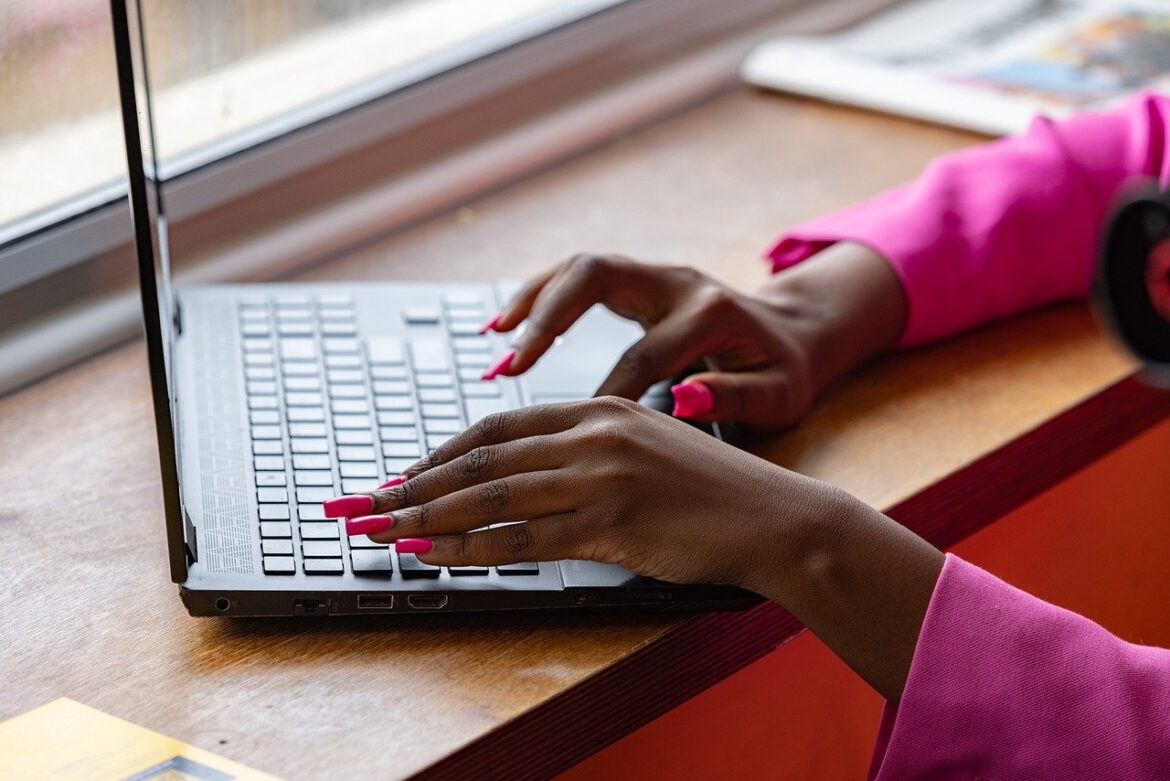 Pixabay laptop-8499942_1280 Close-up of a person wearing a pink sleeve typing on a laptop, with long pink nails and a window in the background