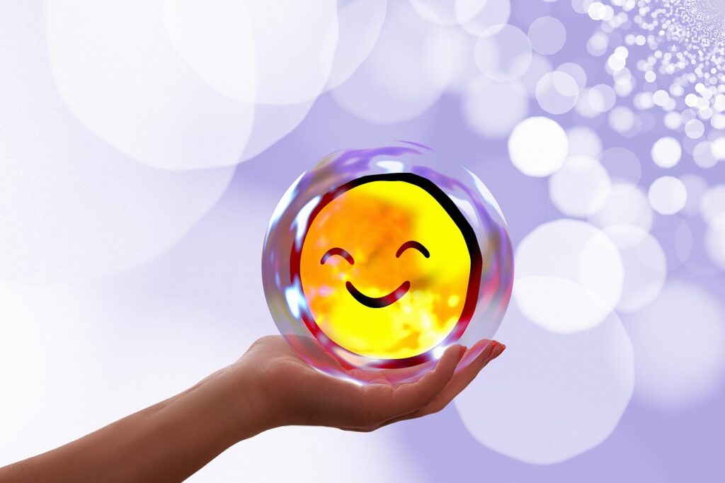 A hand gently holding a glowing, translucent sphere with a smiling face inside, set against a dreamy lavender background filled with soft bokeh light effects.